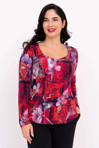 Woman wearing vibrant floral long sleeve top with sweetheart neckline