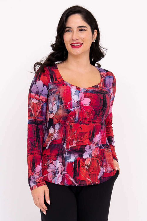 Woman wearing vibrant floral long sleeve top with sweetheart neckline