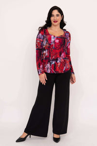 Woman modeling radiant floral top with sweetheart neckline and black wide-leg pants