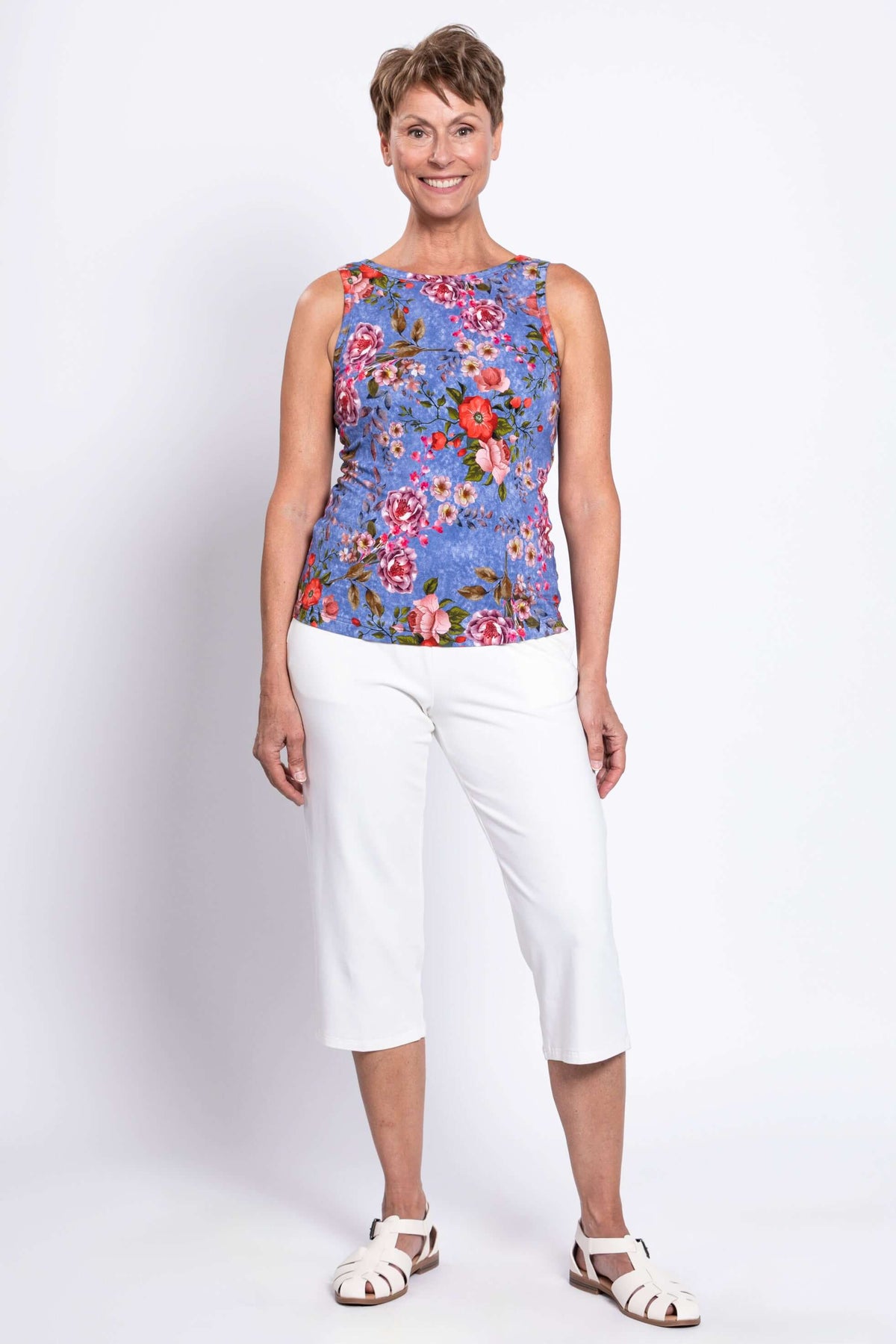 Full body front view of woman wearing high neck side of floral bamboo tank with white pants