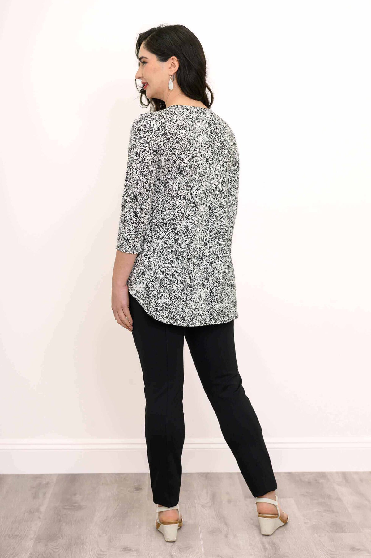 Rear view of woman in rose swirl jazz bamboo top and black pants