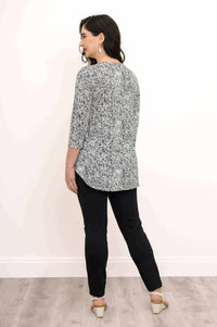 Rear view of woman in rose swirl jazz bamboo top and black pants