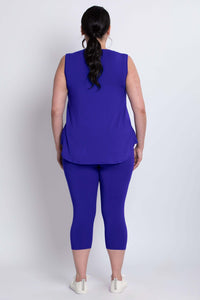 Model showing the back of vibrant blue capri leggings and sleeveless top