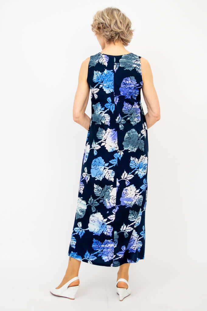 Back view of blue floral dress with pale purple and blue flower pattern, modeled by woman