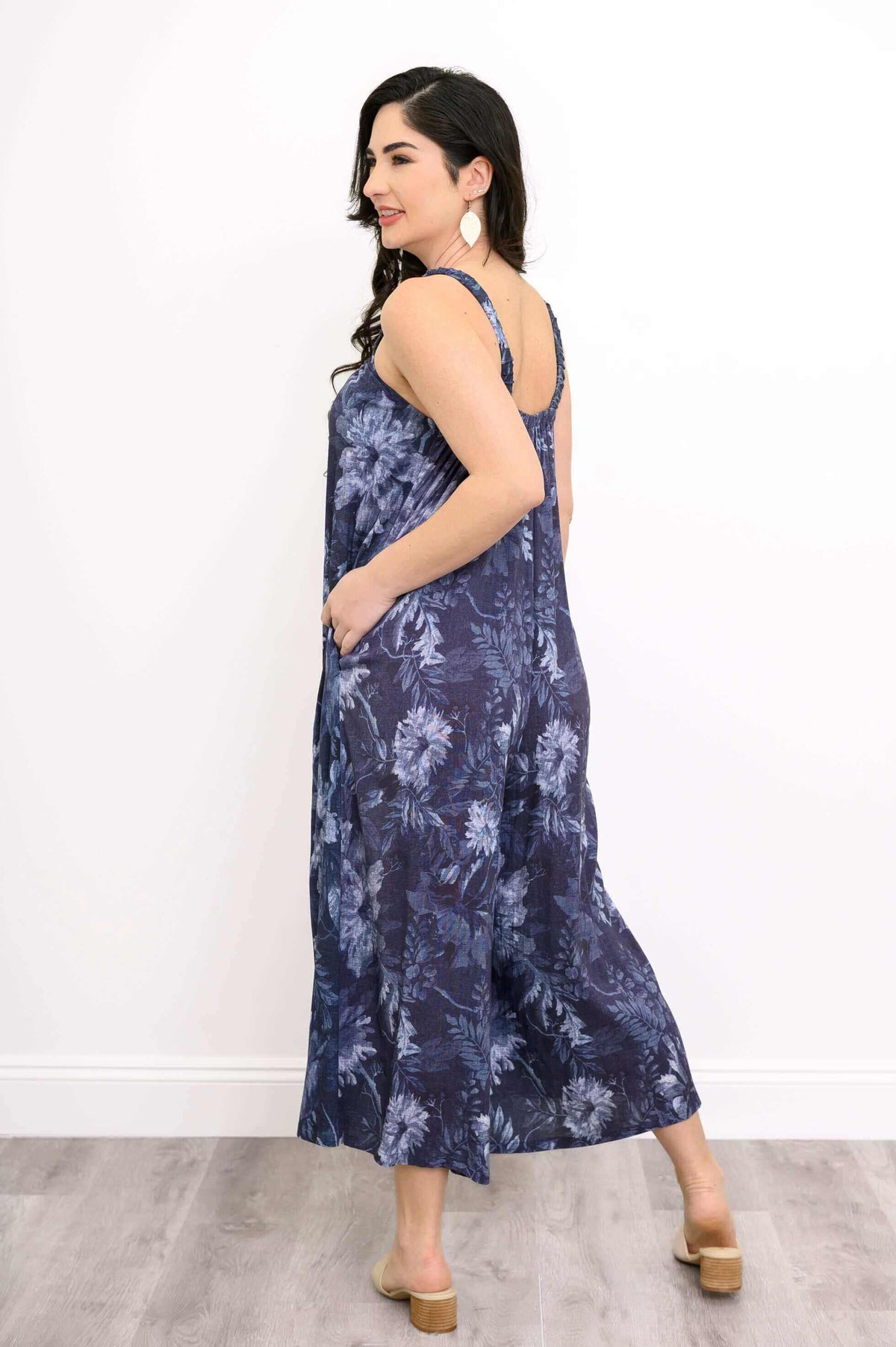 Back view of woman in navy floral jumpsuit showing straps and wide leg fit
