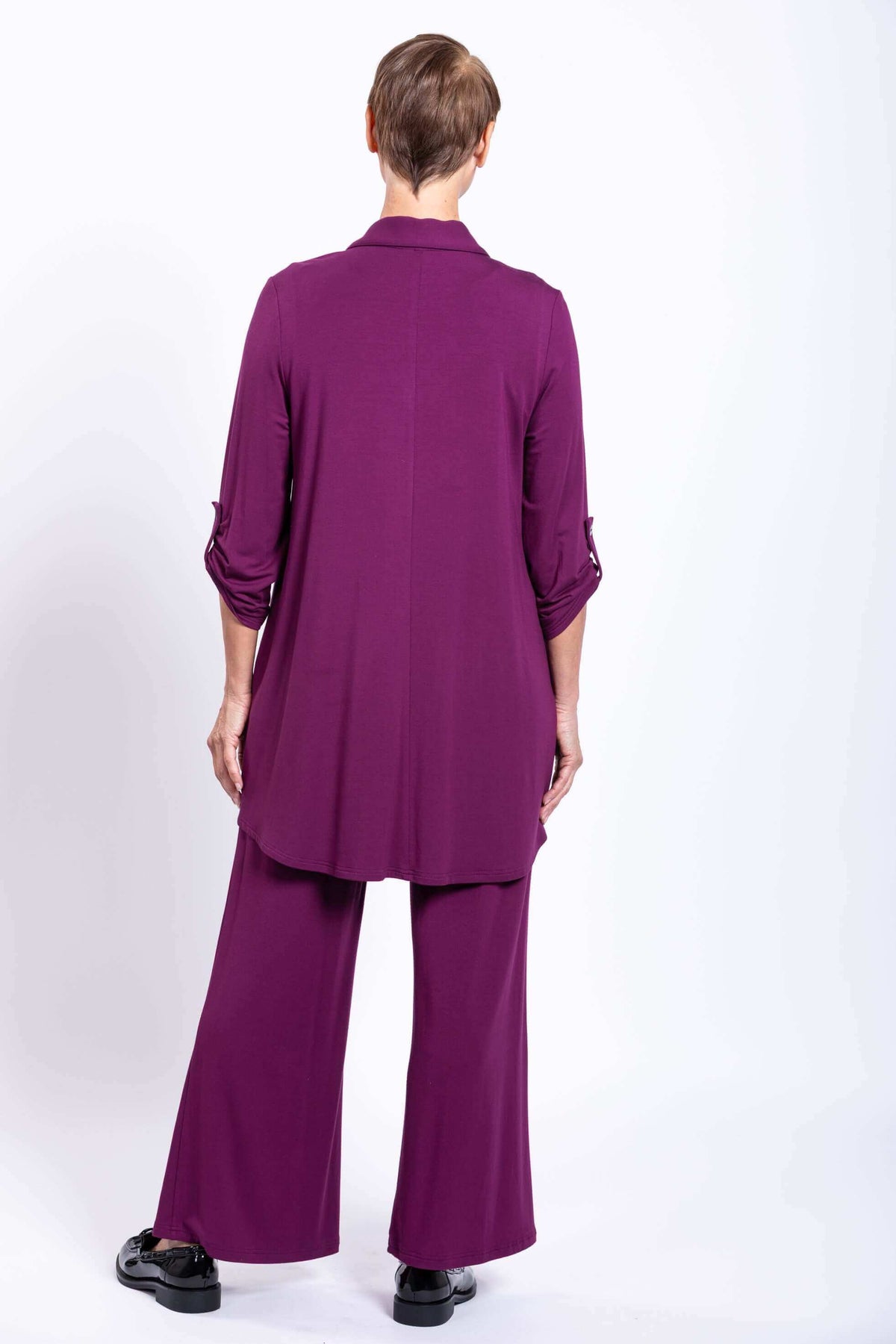 Rear view of a woman wearing a purple bamboo button-up tunic and matching wide pants