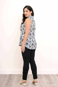 Rear view of woman in black and white floral tank top and black pants