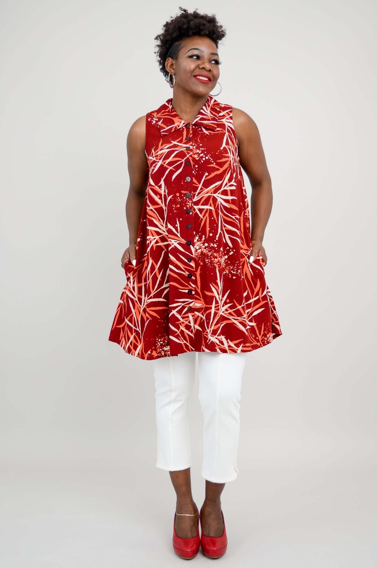 Woman in red bamboo print A-line tank showing side seam pockets
