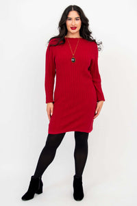 Woman modeling a red cable knit sweater dress with hands on hips, facing forward