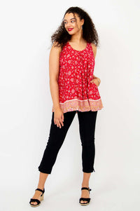 Woman in red floral pleated tank top striking a casual pose