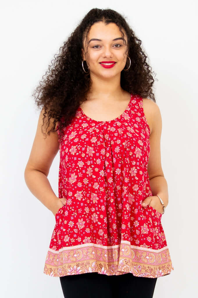 Woman wearing a red floral pleated tank top with pockets, front view