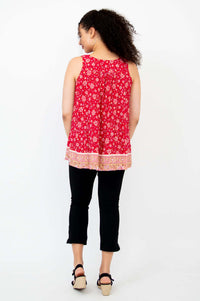 Back view of woman wearing a red floral pleated tank top with a decorative border