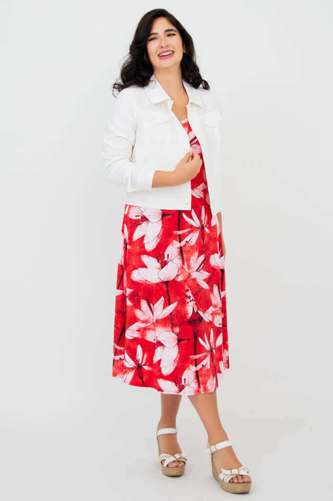 Woman in red floral tank dress styled with a white jacket