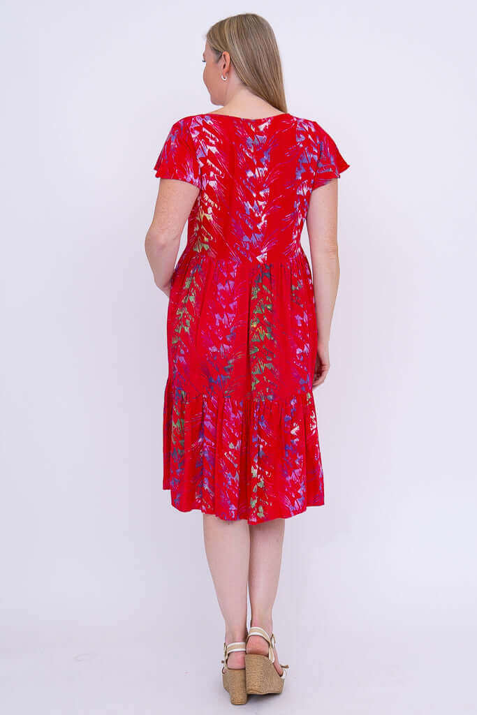 Back view of a woman in a red floral tiered dress with short flutter sleeves
