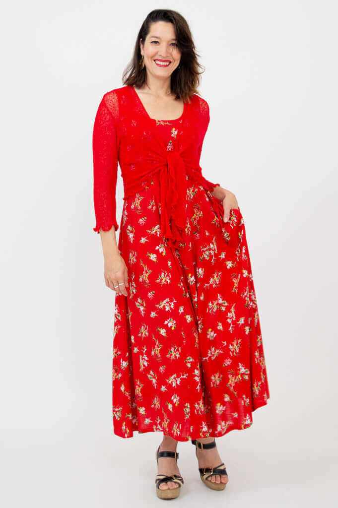 Woman wearing a red sleeveless floral maxi dress with a matching red tie cardigan