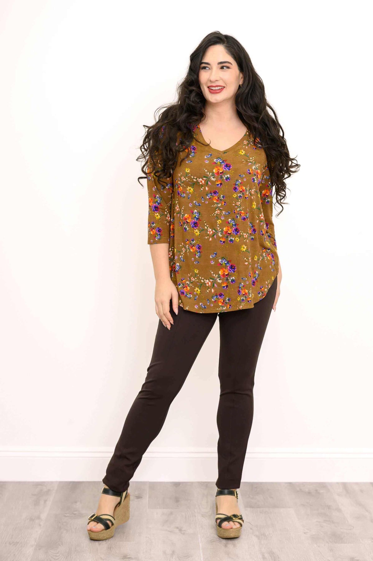 Woman posing in marigold floral V-neck bamboo top with relaxed fit