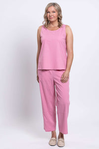 Woman in pink sleeveless top and cropped pants, standing with a relaxed pose, front view