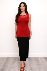 Full body view of woman wearing a red tank top with mesh detail, black skirt, and red sandals
