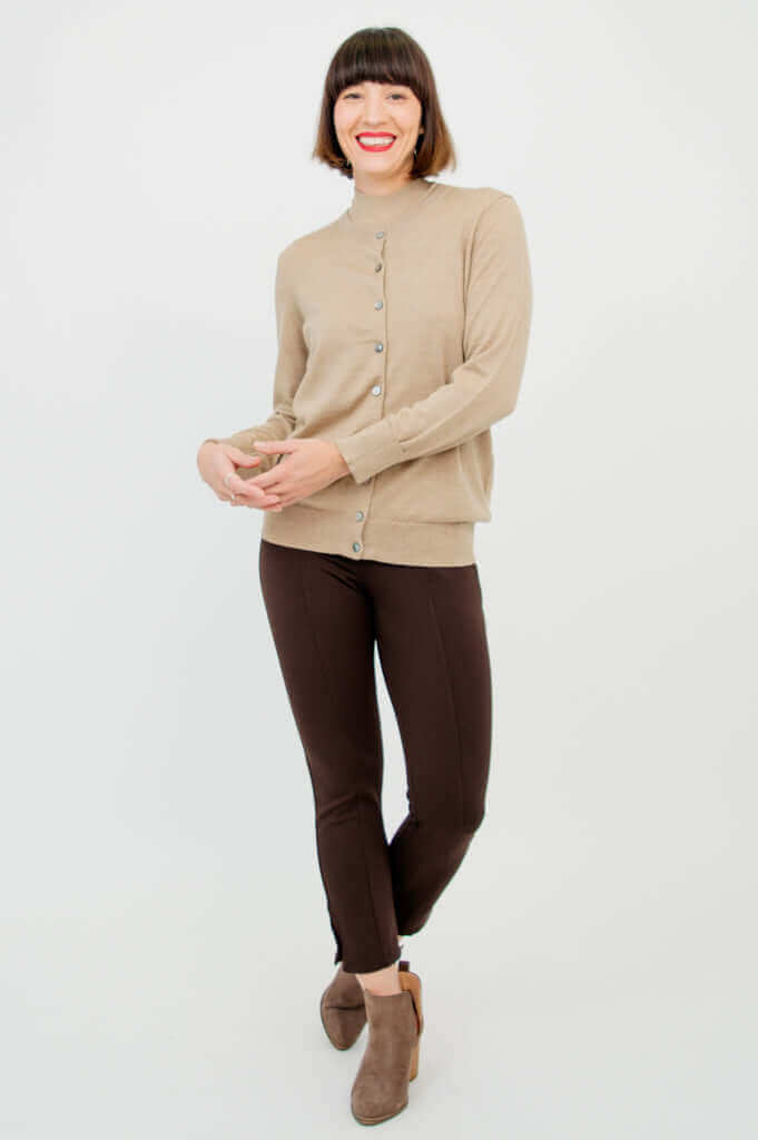 Woman with tan button-up cardigan layered over sleeveless tan sweater