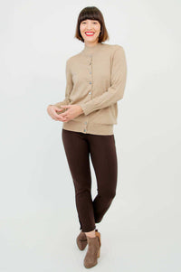 Woman with tan button-up cardigan layered over sleeveless tan sweater
