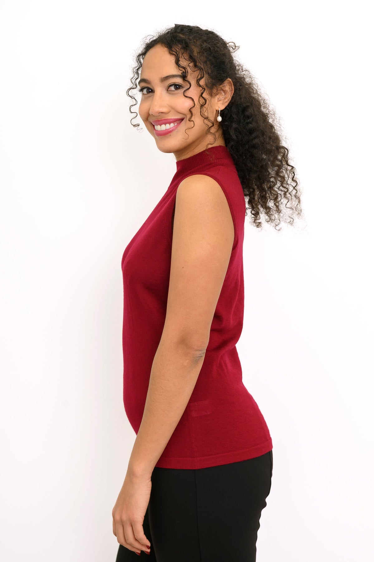 Profile shot of a dark red sleeveless knit top showing slim fitting silhouette and side seam detail.