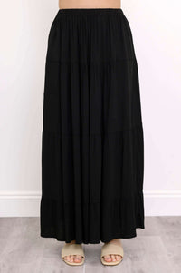 Front view of black tiered maxi skirt and beige sandals