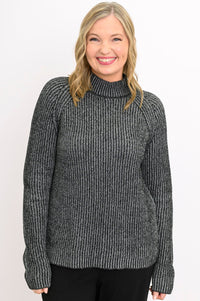 Smiling woman wearing a chunky charcoal gray knit sweater with a low mock neckline and relaxed raglan sleeves.