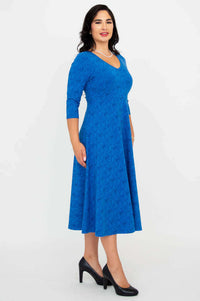 Side profile of a woman in a royal blue midi dress with V-neckline and 3/4 sleeves