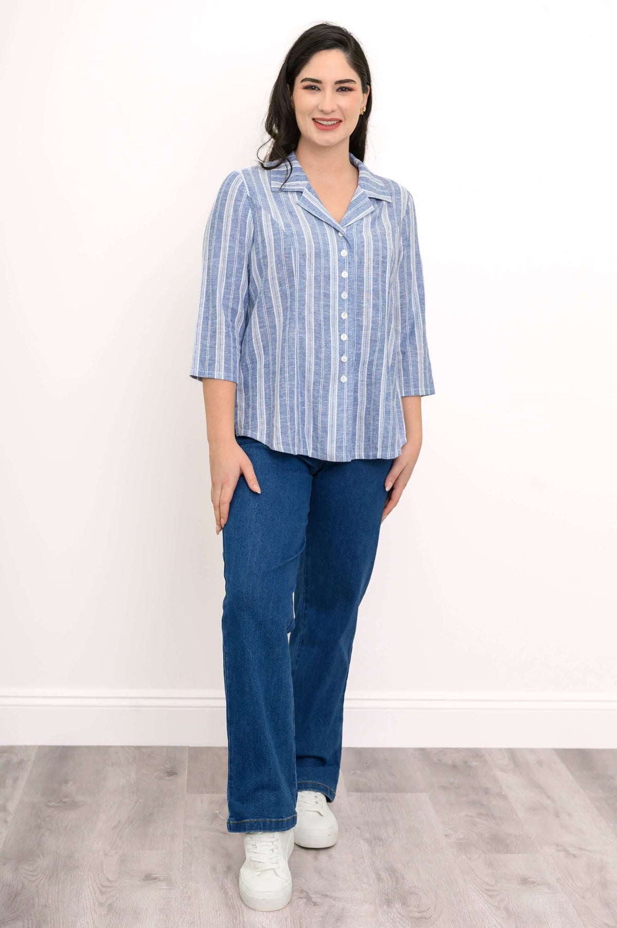 Woman modeling Samantha striped button-up top with blue jeans and white sneakers