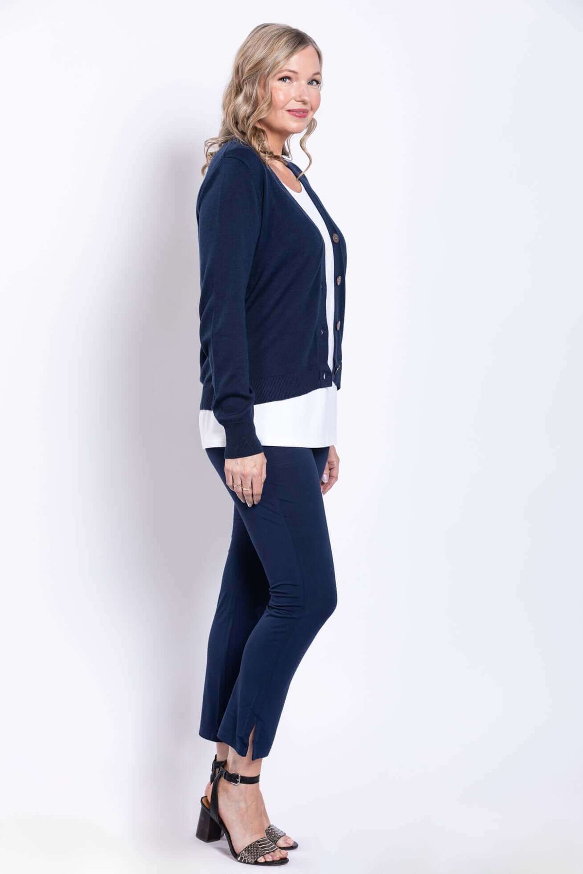 Model in navy slim-fit pants and cardigan, side view showing ankle slit detail