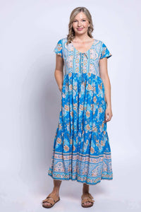 Front view of woman wearing blue floral Sharpie Dress with flutter sleeves and pockets