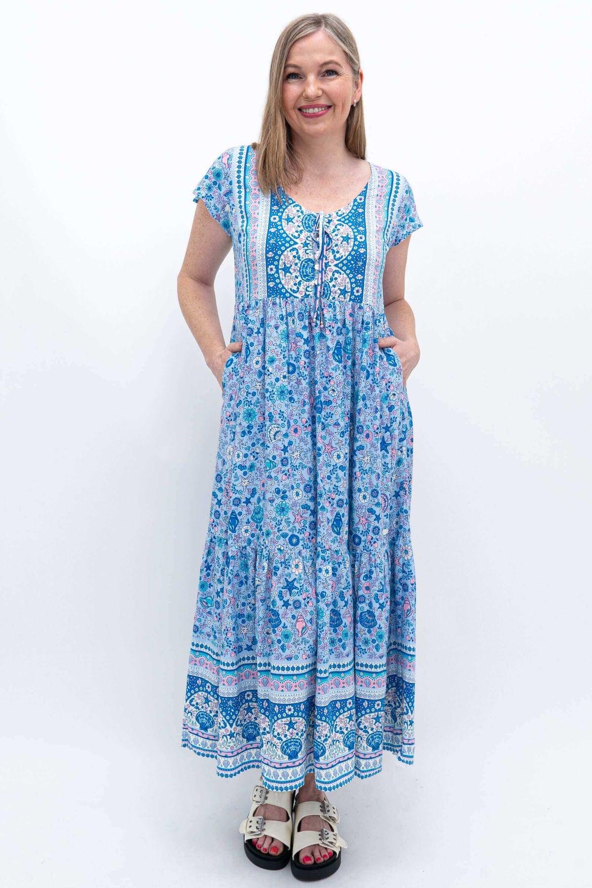 Woman showing pockets of blue patterned Sharpie Dress