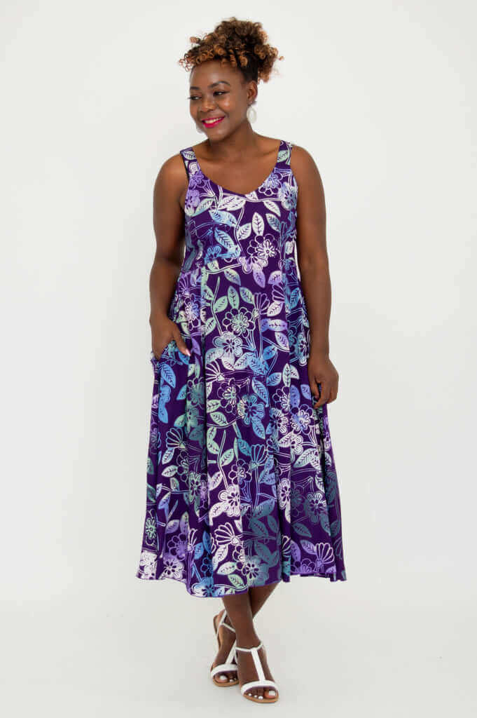Smiling woman in purple floral A-line midi dress facing forward