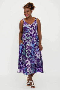 Smiling woman in purple floral A-line midi dress facing forward