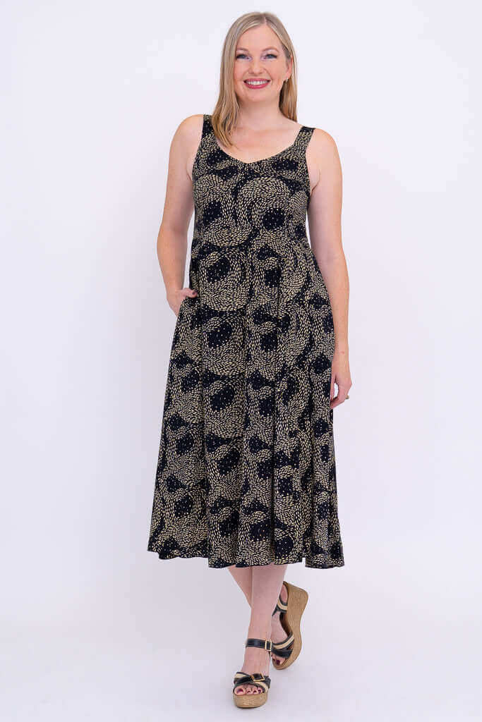 Full front view of woman in Shauna empire waist dress, hands in pockets