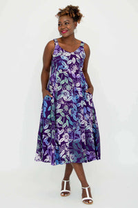 Woman posing in a purple and blue floral print empire waist dress with pockets