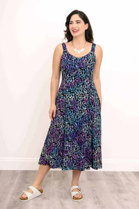 Model smiling in front view, wearing Shauna midi dress with swirly pattern and pockets