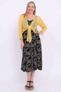Front view of Shauna dress paired with yellow shrug, hands on hip and pocket