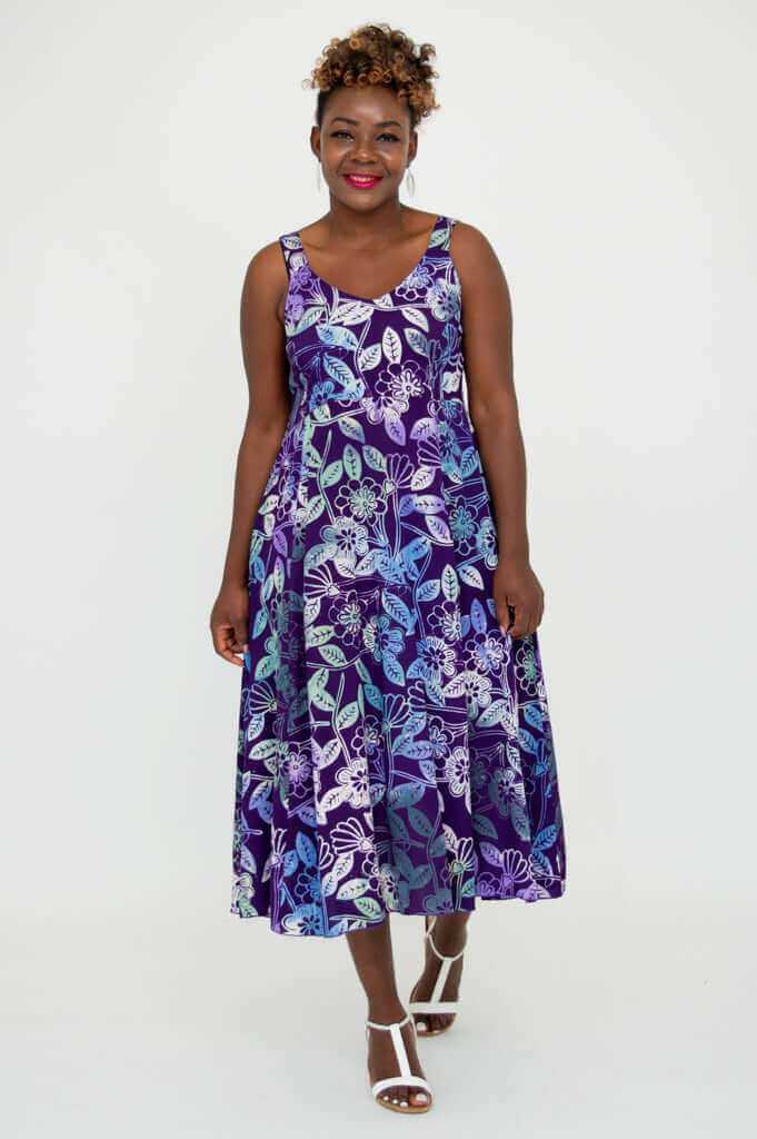 Woman walking forward in vibrant purple floral A-line dress with wide straps