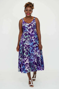 Woman walking forward in vibrant purple floral A-line dress with wide straps