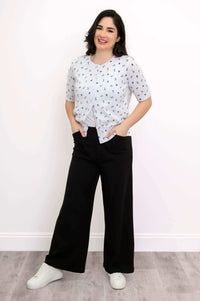Woman in Shen nautical cardigan with hands in pockets, styled with black pants and white sneakers