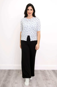 Woman in Shen nautical print short sleeve cardigan and black pants facing forward