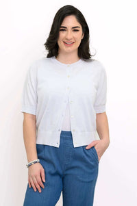 Model wearing a light cotton short-sleeve button-up cardigan with blue trousers
