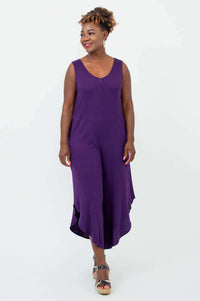 Woman in purple jumpsuit looking to the side, showing relaxed fit and asymmetrical cropped legs
