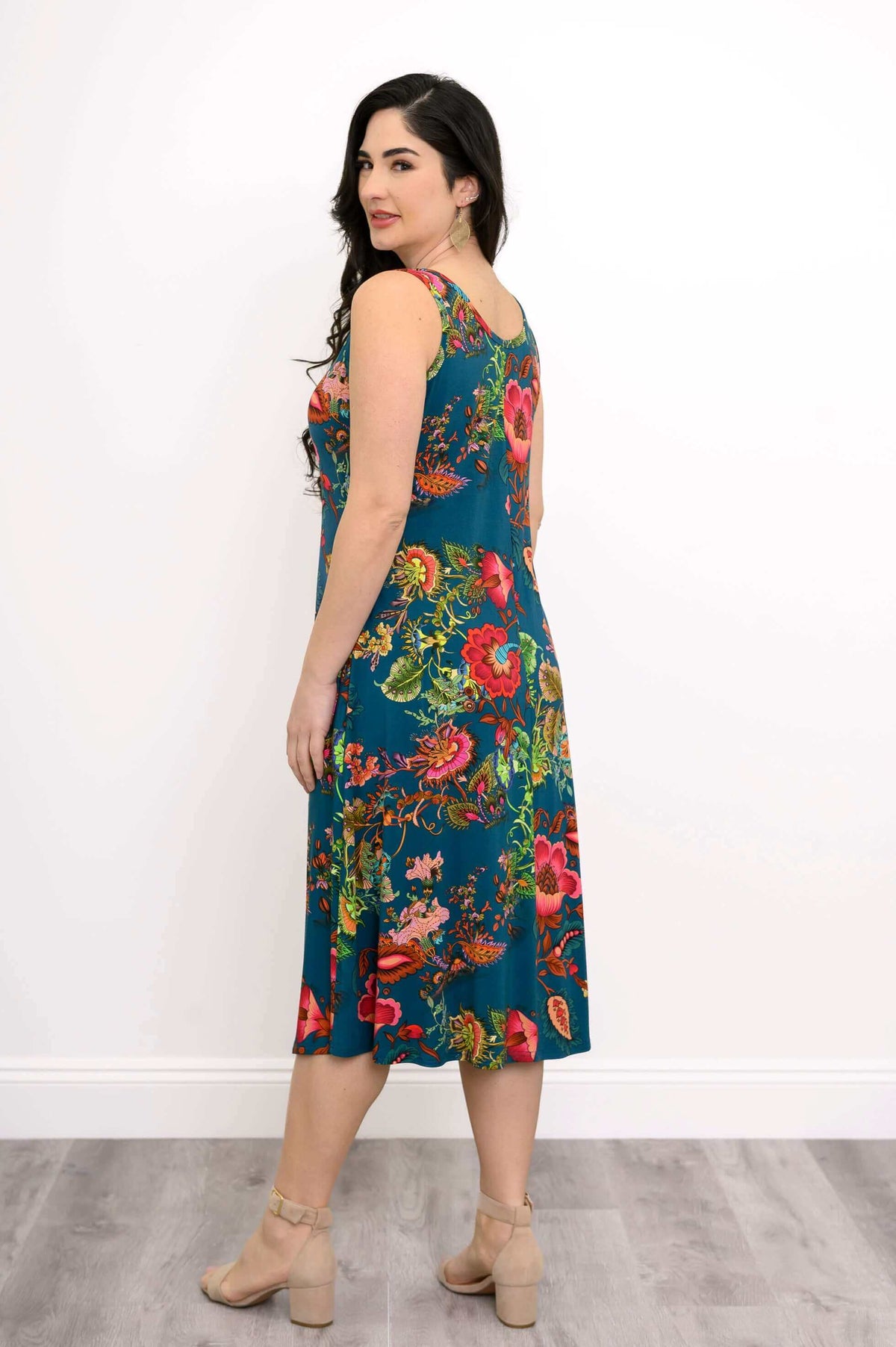 Side-back view of a woman in a floral teal tank dress showing a soft A-line shape