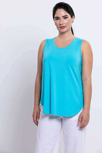 Side-front view of woman in an aqua sleeveless tank top and white pants