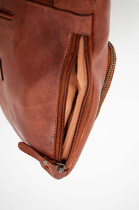 Side view of the bag showing open zippered compartment and lining