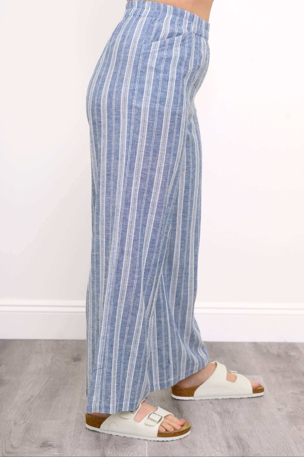 Close-up side view of woman wearing blue and white striped pants with pockets