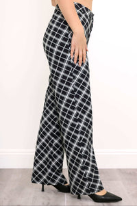 Side view of black and white plaid trousers showing leg detail