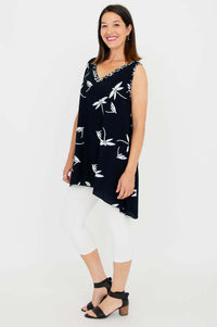 Side view of woman in black handkerchief-hem tunic top with white floral print